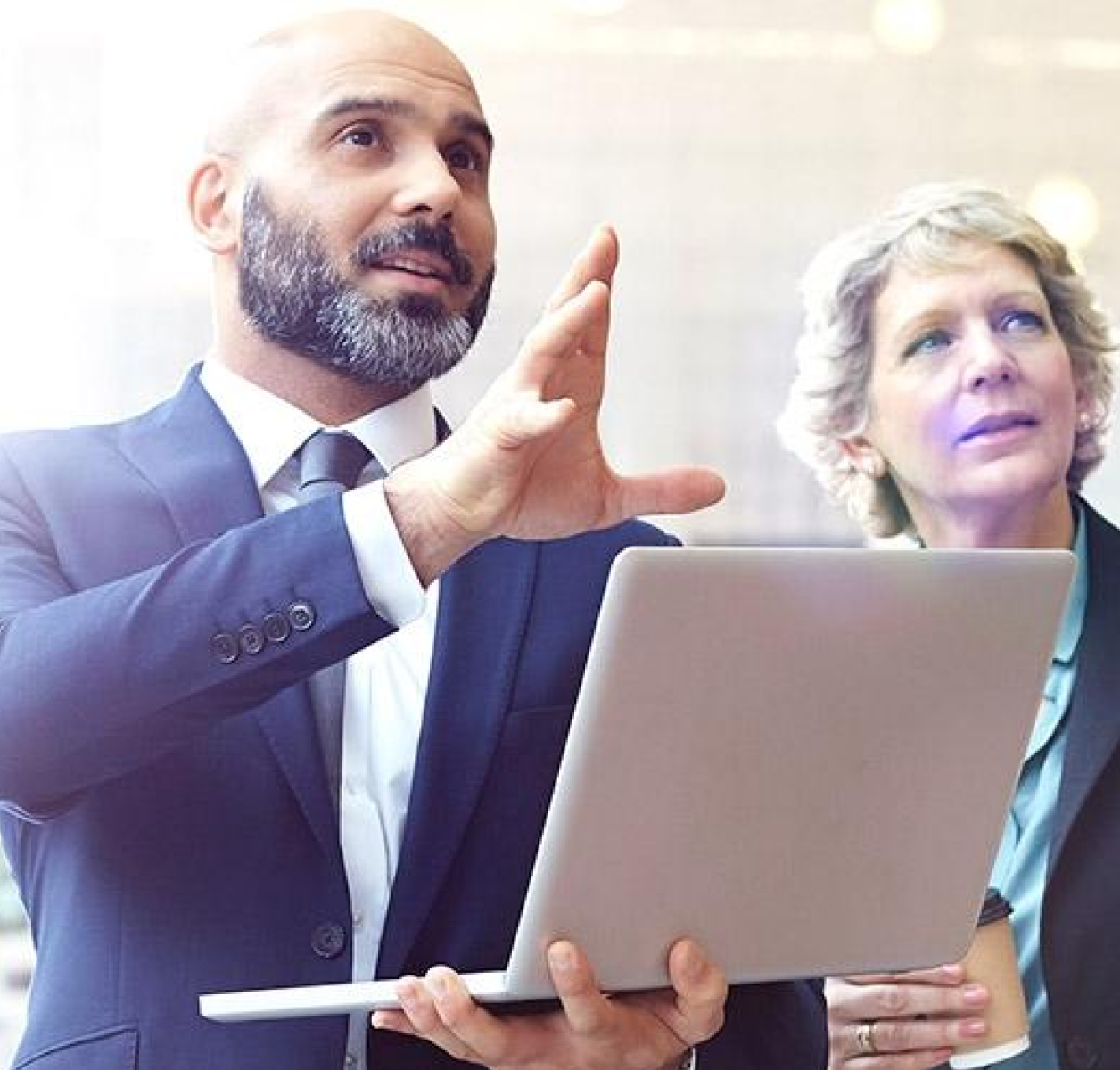 A financial advisor holding laptop speaks to woman