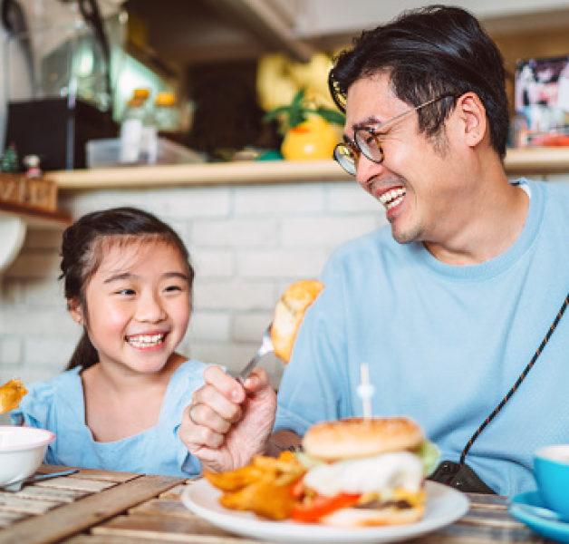 Father and daughter eating a meal and smiling