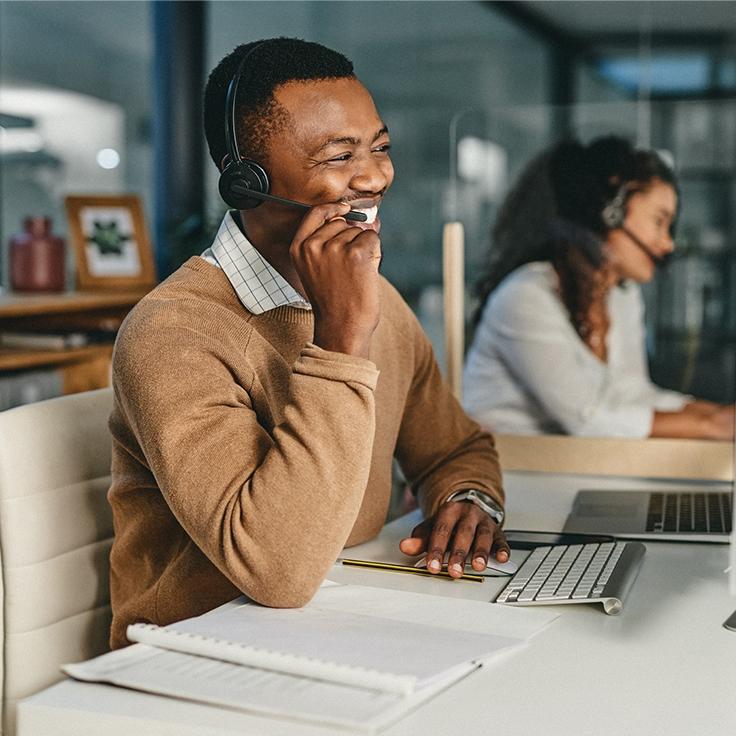 A help operator sits at desk talking on phone