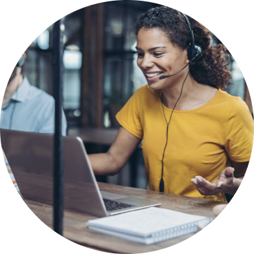 Woman in headset talking with a laptop on the desk in front of her