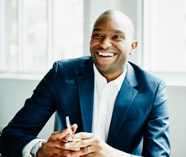 Man in suit smiling with his phone in hand