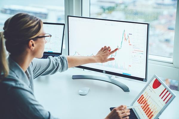 Woman reviewing charts on computer screen