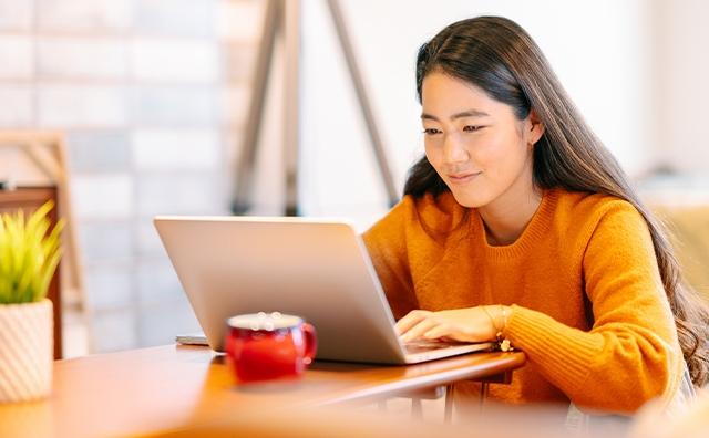 A young woman works at home on laptop computer