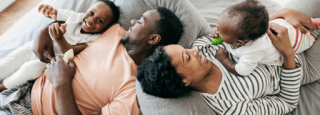 A family laying down on a couch