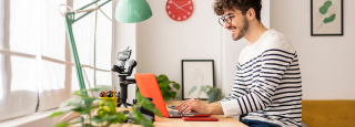 a man sits at home working on laptop